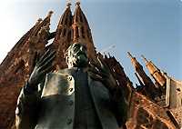 A statue of Antonio Gaudi y Cornet in front of his Sagrada Familia Cathedral.